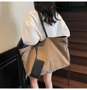Dettaglio della borsa tote in tela kaki con cinturino in pelle e mini pochette nera