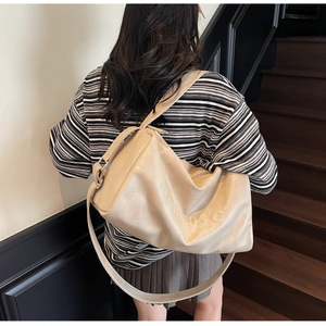 Detail of cream white large tote bag with 1995°C embossed logo and wide strap