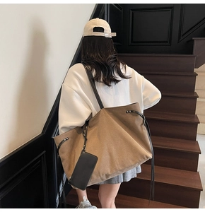 Dettaglio borsa tote grande in tela marrone intrecciata con sottili spalline in pelle
