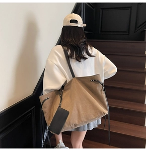 Dettaglio della borsa tote in tela kaki con cinturini in pelle e pochette rimovibile