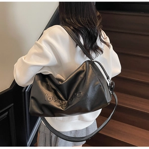 Close-up of black tote bag with embossed love105°C lettering on premium PU leather