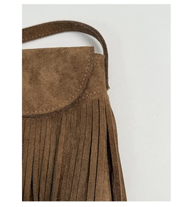 Macro shot of dark brown suede shoulder bag featuring long fringe details and premium texture