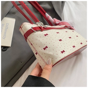 Vue détaillée du sac polochon crème à pois rouges et ruban de dentelle élégant
