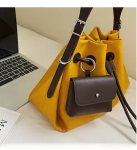 Detailed view of polished silver metal rings and textured leather drawstring bucket bag