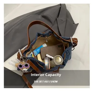 Detail view of denim bucket bag interior showing large capacity for phone and cosmetics