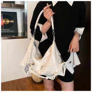 Detail of white glossy patent leather tote with woven rope trim and metallic zipper