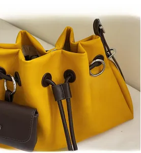Detail of yellow drawstring bucket bag showing durable cinch closure and silver metal ring