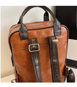 Detail view of adjustable shoulder straps and litchi texture on brown backpack