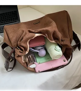 Spacious interior of brown tote bag holding a tablet, water bottle and umbrella