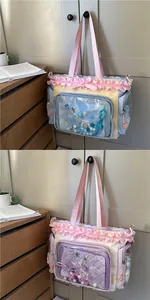 Detail of Japanese style ita-bag with lace ruffles, satin bows and transparent PVC window