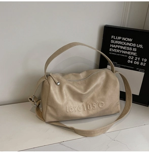 Detail of beige Boston tote bag with embossed love 105 text on matte leather finish