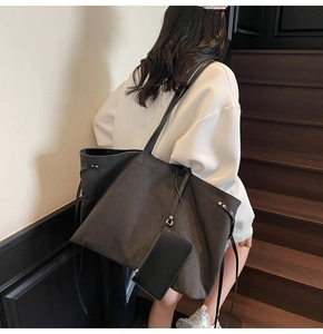 Vista posteriore di una grande borsa tote in tela con finiture in pelle e pochette rimovibile