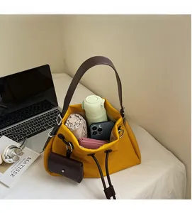 Interior detail of yellow drawstring bucket bag showing water bottle and phone storage