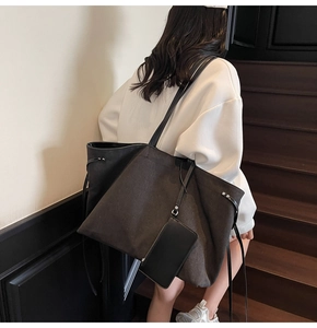 Dettaglio borsa tote grande in tela scura con pochette interna e design spazioso e minimalista