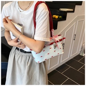 Détail du sac à nœud rose montrant la bordure en dentelle et le pendentif d'ours