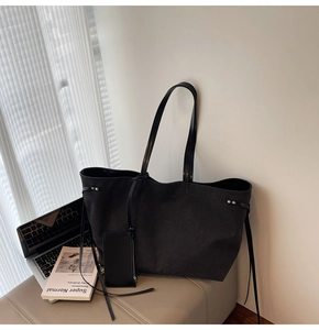 Dettaglio della grande borsa tote nera in tela con scomparto laptop e mini pochette