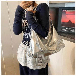 Detail of silver metallic hobo bag with crinkled finish and braided knot strap accents