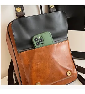 Detail view of large front pocket on bicolor PU leather backpack for smartphone storage