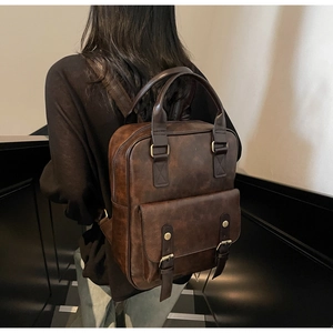 Detail of dark brown vintage PU leather backpack with adjustable straps on a model