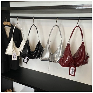 Detailed display of glossy half-moon underarm bags in white, black, silver, and burgundy
