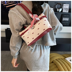 Détail du sac à motif nœuds roses avec bordure rouge, ruban vichy et breloque cœur
