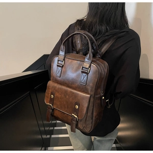 Rear view of model wearing a vintage dark brown PU leather backpack with double straps