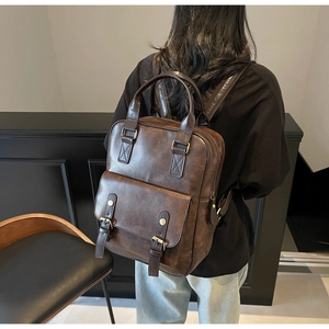 Model view of a vintage dark brown PU leather backpack with dual metallic buckles