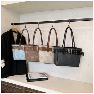 Nahaufnahme von vierfarbigen modischen Oversized-Tote-Bags auf einem Ständer mit Goldschnallen