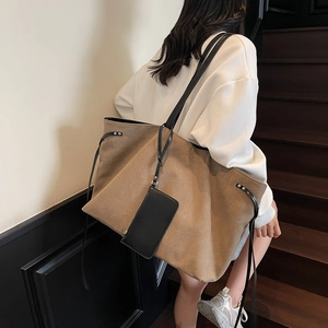 Grande borsa tote in tela kaki con tracolle sottili nere indossata da modella