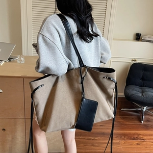 Grande borsa tote kaki in tela con tracolle in pelle nera vista dal retro del modello
