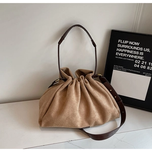 Detail of camel suede pleated tote bag with adjustable brown leather shoulder strap