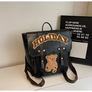 Detail of black PU leather backpack with Holiday chenille patch and brown teddy bear