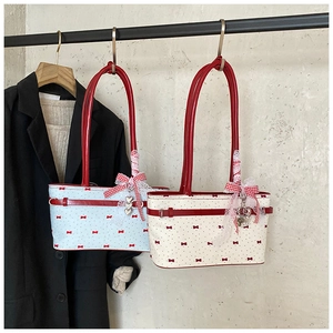 Détail du cabas vintage avec motif de nœud rose, dentelle et pendentif cœur en métal