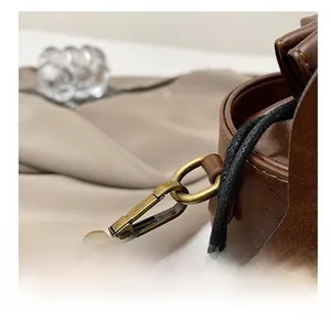 Detail of the vintage bronze swivel clasp and brown leather strap of the horse bag
