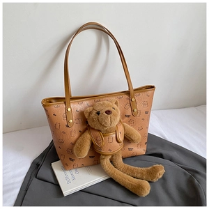 Close-up of brown tote bag with cute bear patterns and 3D plush bear keychain