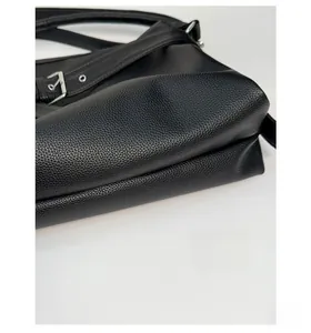 Macro shot of the thickened base and lychee grain leather detail on the black tote bag
