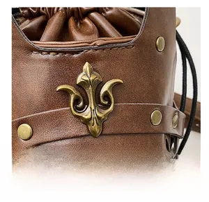 Detail of vintage brown leather bag with bronze lily ornament and metallic rivets