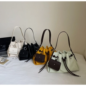 Detail of drawstring bucket bags in white, black, yellow, and green with mini pouches