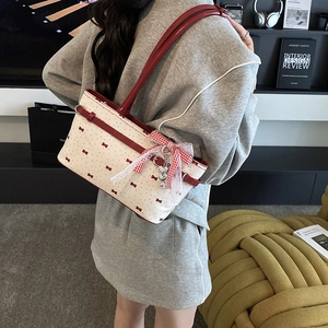 Sac à main rose à nœud avec pois rouges et dentelle porté par un mannequin de dos