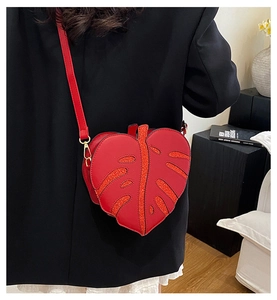 Detail of red leaf-shaped PU leather crossbody bag with glitter leaf veins on a model