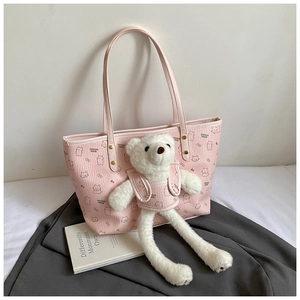 Detailed view of pink tote bag with bear pattern and hanging plush bear charm accessory