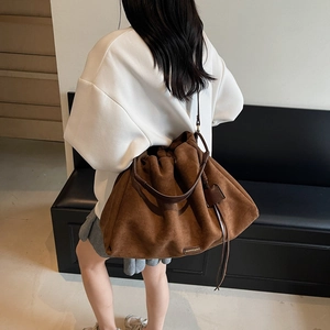 Large brown suede tote bag with drawstring closure and stylish shoulder strap for women