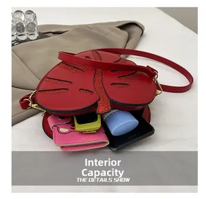 Internal capacity of the red maple leaf crossbody bag showing phone and cosmetics