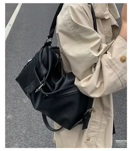 Detail of black pebbled leather tote bag with silver buckle and stylish pleated design