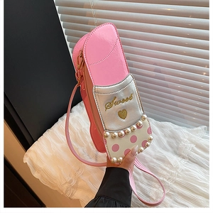 Détail d'un sac à bandoulière rose en forme de rouge à lèvres avec perles et broderie Sweet
