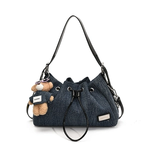 Deep blue denim tote bag with drawstring closure and cute plush bear charm accessory