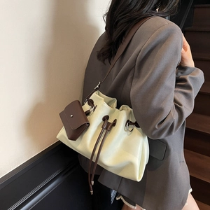 Chic mint green drawstring bucket bag with brown straps and mini pouch accessory