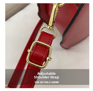 Detail of red PU leather shoulder strap with adjustable golden buckle and metal swivel hook