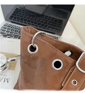 Close-up of silver metal ring hook and buckle detail on a brown leather tote bag