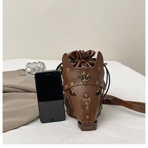 Detailed view of a vintage horse head crossbody bag with bronze rivets and phone size scale